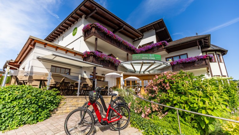 Vitalzeit Hotel Weber, © Wiener Alpen/Martin Fülöp Exterior view of the Vitalzeit Hotel Weber with flowers and bicycle.