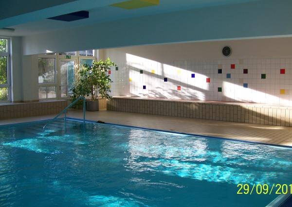 Indoor swimming pool Ladendorf, © Gemeinde Ladendorf Interior view of an indoor swimming pool with blue water and colorful tiled wall.