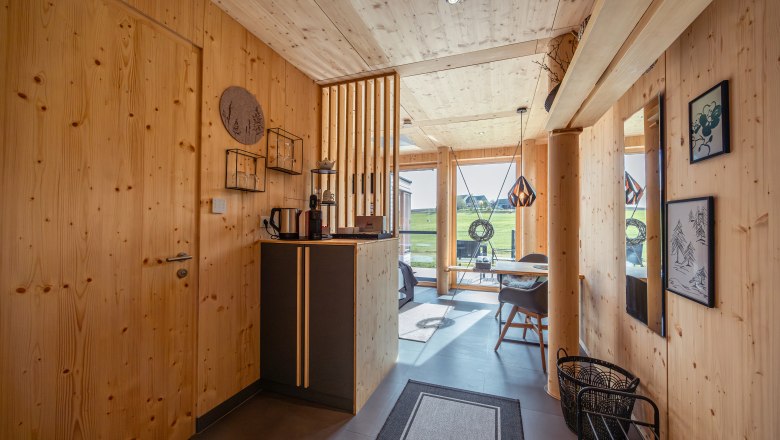 roo'n, © Niederösterreich Werbung / Maximilian Pawlikowsky Interior view of a modern wooden house with large windows and minimalist furnishings.