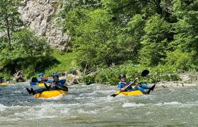 Tubing Wilderness Center Nasswald, © Georg Bergthaler People tubing on a river in a green, wooded setting.