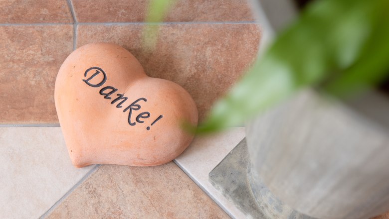 Guesthouse Thermenblick, © Fam. Lachmayer Heart-shaped stone with the inscription 'Thank you' on tiled floor next to plant pot.