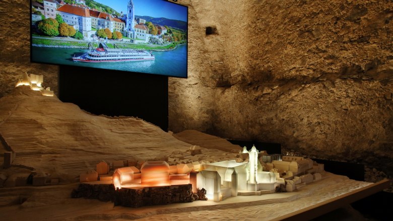 Exhibition at Dürnstein Abbey, © Weinfranz Model of Dürnstein with illuminated pen and photo in the background.