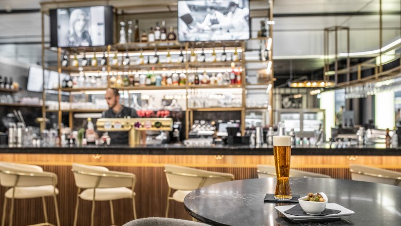 Wolfgang Puck Kitchen + Bar, © Flughafen Wien Wolfgang Puck Kitchen, bar with waiter