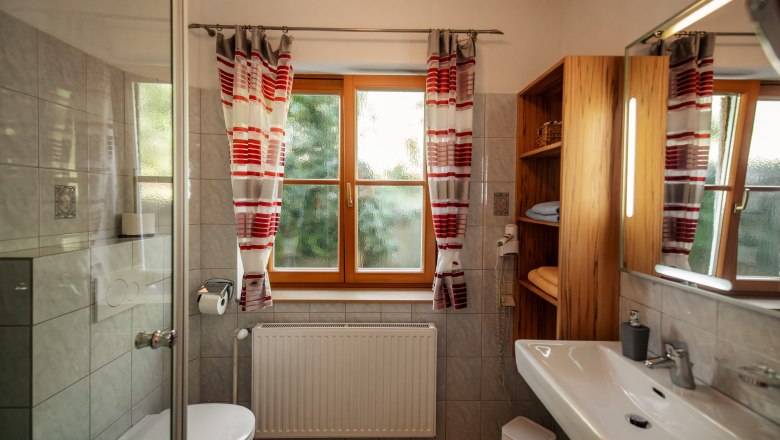 Guesthouse-Winzerhof Bernhard, © Jolly Schwarz Modern bathroom with window, shower cubicle, washbasin and shelves.