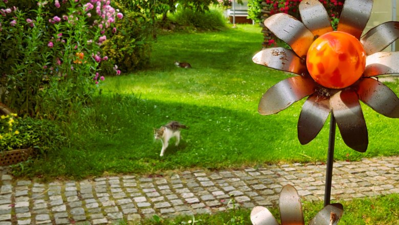 Garden, © Fam. Heinrich A garden with flowers, a cat and metal flowers.