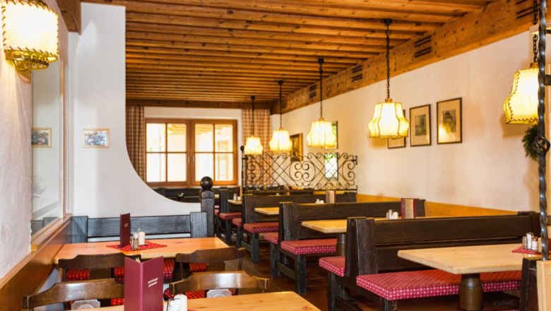 Wine tavern, © Wein und Heuriger Ganneshofer Cozy interior of a traditional wine tavern with wooden furniture and checkered seat cushions.