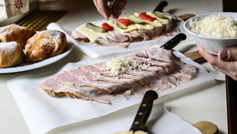 Simon Genuss wine tavern, © Most Michl Preparation of sandwiches with ham and cheese, as well as pastries.