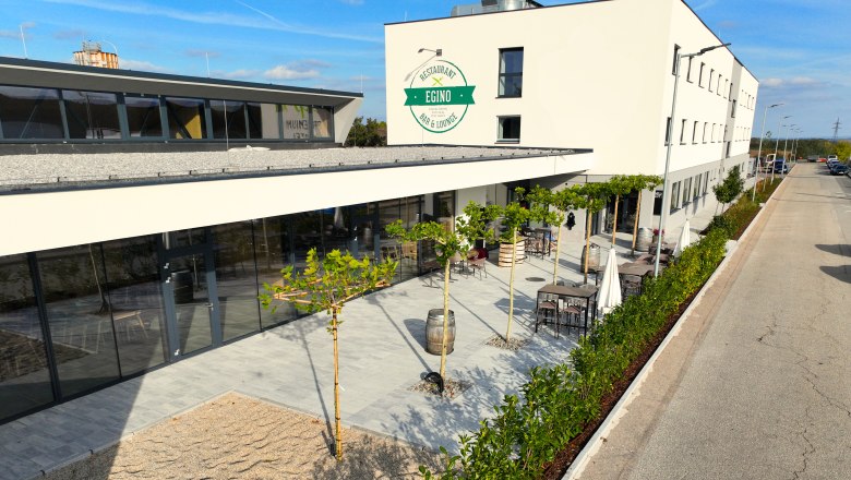 Exterior view, © EGINO-Premium Hotel, Restaurant & Bar Exterior view of a modern building with terrace and plants.