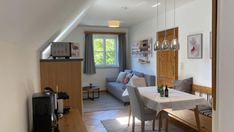 Country house Rossatz, © Familie Schlager Cozy living room with dining table, sofa and kitchenette in a country house style.