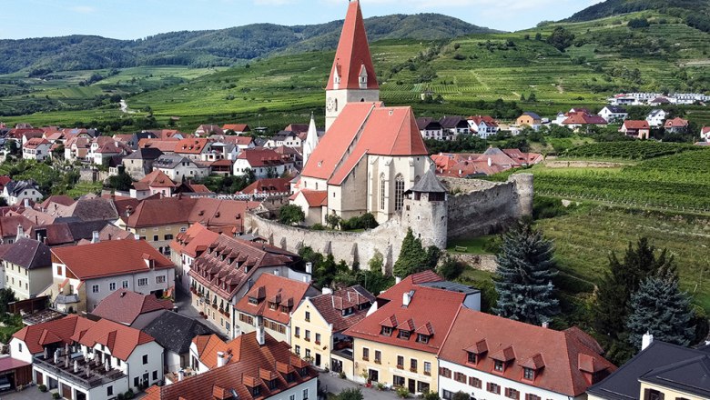 Pension Guesthouse Heller, © Annemarie Heller Aerial view of a village with a church and vineyards in the background.