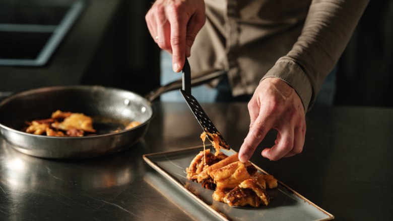 W4, © Weinviertel Tourismus / Michael Reidinger Person arranges food on a rectangular plate.