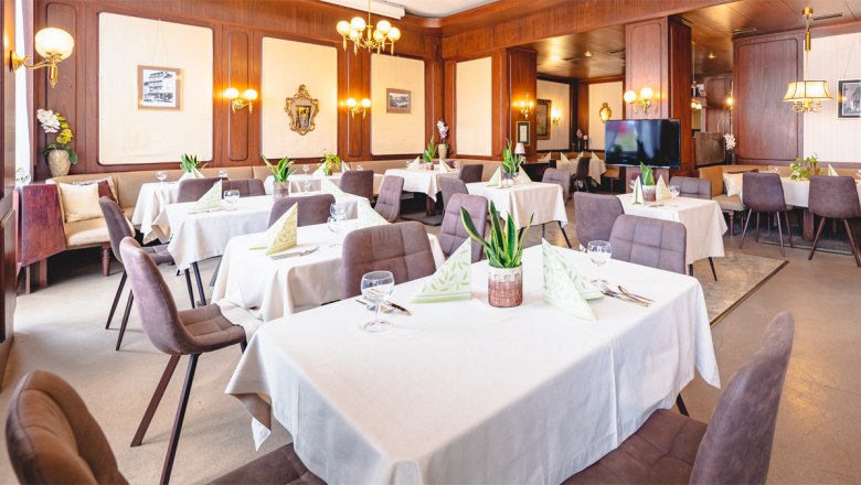 Hotel Zentral Restaurant, © busyshutters/ Hotel Zentral Schwartz GmbH Elegant restaurant with laid tables, white tablecloths and plants.