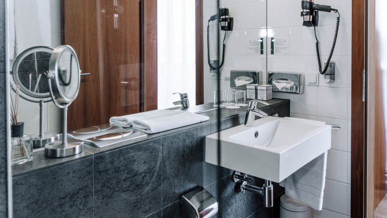 Bathroom, business terrace at HEINhotel vienna airport, © HEINhotel vienna airport Modern hotel bathroom with washbasin, mirror and towels.