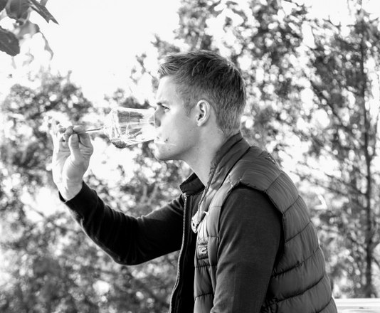 Winemaker Gerald Pass, © Manfred Koppensteiner Man drinking wine on a terrace.