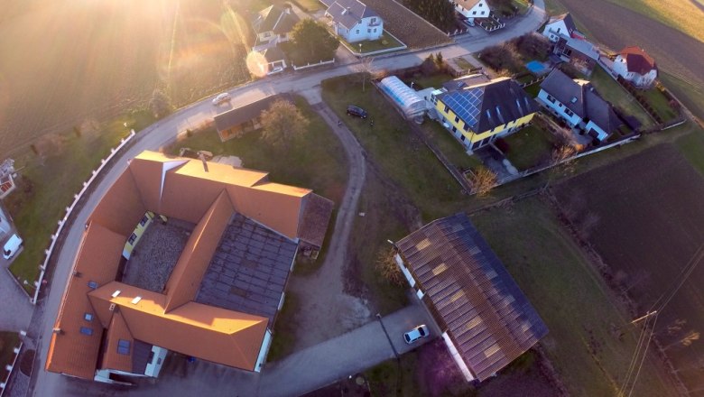 Aerial view, © zur Verfügung gestellt: Weinbau Häusler Aerial view of a village with houses, streets and fields at sunset.