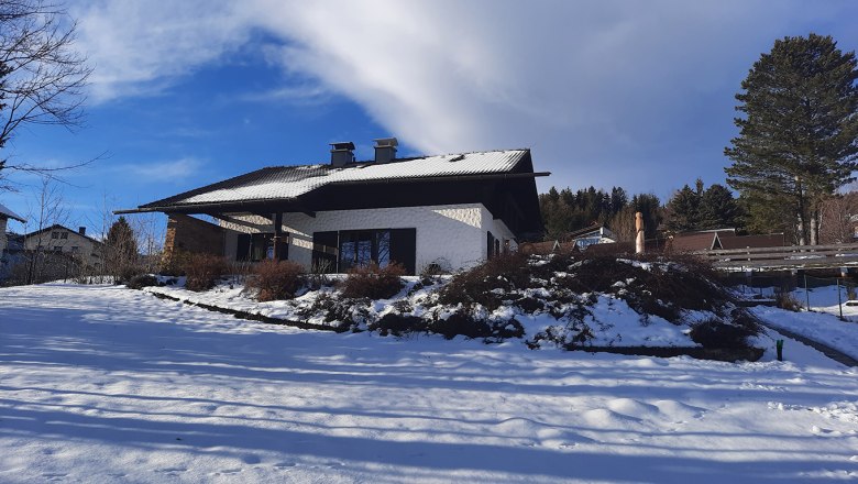 Belle Air Lodge in winter, © Christoph Gierlinger A snow-covered house in winter with a blue sky and trees in the background.