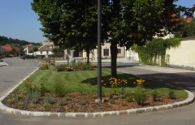 Venus of Eggendorf, © Stadtgemeinde Maissau A well-kept flower bed with yellow flowers and trees in a quiet residential street.