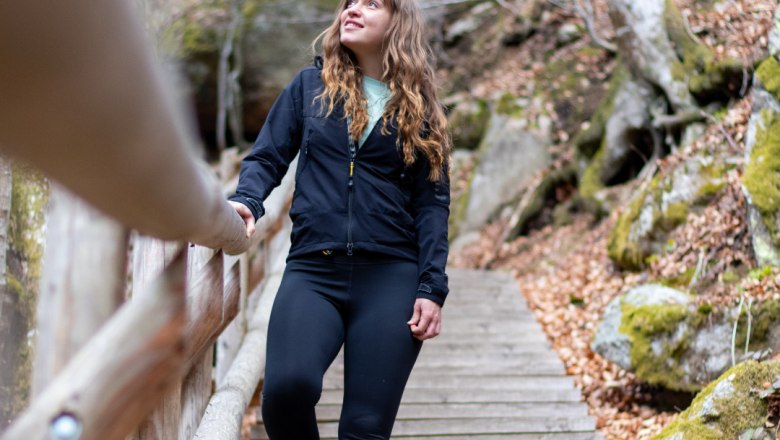 Hiking in the Ysper Gorge, © Familie Moser A woman walks on a wooden staircase in a wooded area.