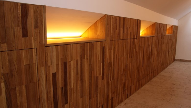 Gear, © © Weingut Josef Bauer Wood-clad wall with indirect lighting in a hallway.