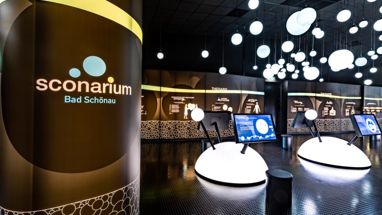 Sconarium - exhibition on natural carbon dioxide, © Wiener Alpen, Christian Kremsl Interior view of the Sconarium exhibition in Bad Schönau with interactive displays and illuminated spheres on the ceiling.