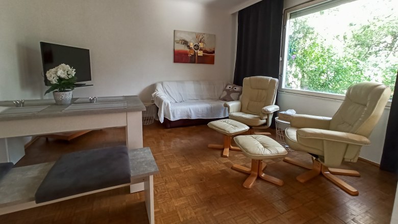Living and dining area, © Multimedia Lauda Living room with sofa, two armchairs, table and large window.
