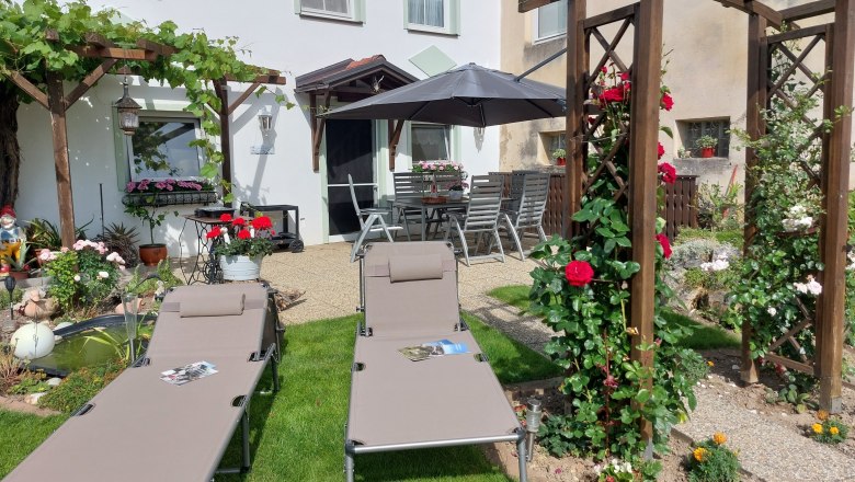 Cozy terrace in the inner courtyard, © Erika Kellner Garden with sun loungers, pergola and flowers.