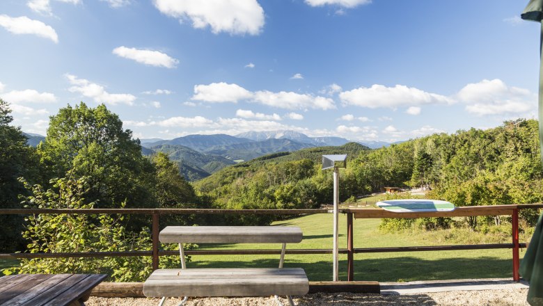 Viewpoint Waxeneckhaus, © Wiener Alpen, Foto: Franz Zwickl View from the Waxeneckhaus of wooded hills and mountains under a blue sky with clouds.