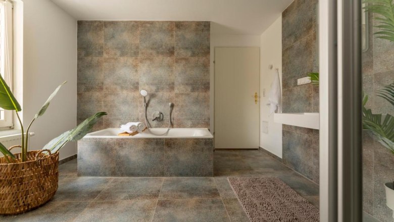 Bathroom, © Guestia GmbH Modern bathroom with bathtub, plants and towel.