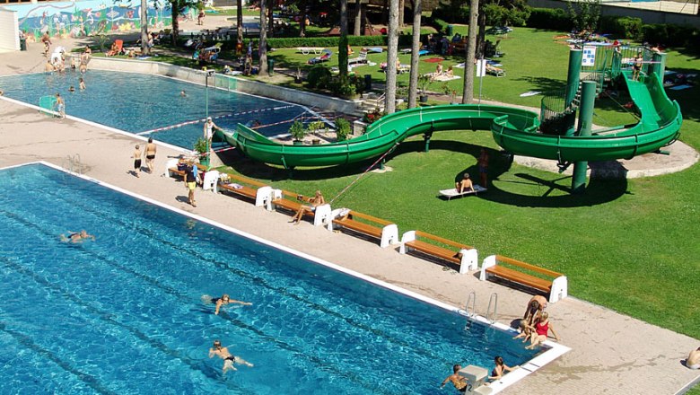 Thermal sports pool Mannersdorf am Leithagebirge, © Stadtgemeinde Mannersdorf/Leithagebirge An outdoor pool with two swimming pools, a green water slide and sunbathing lawn.