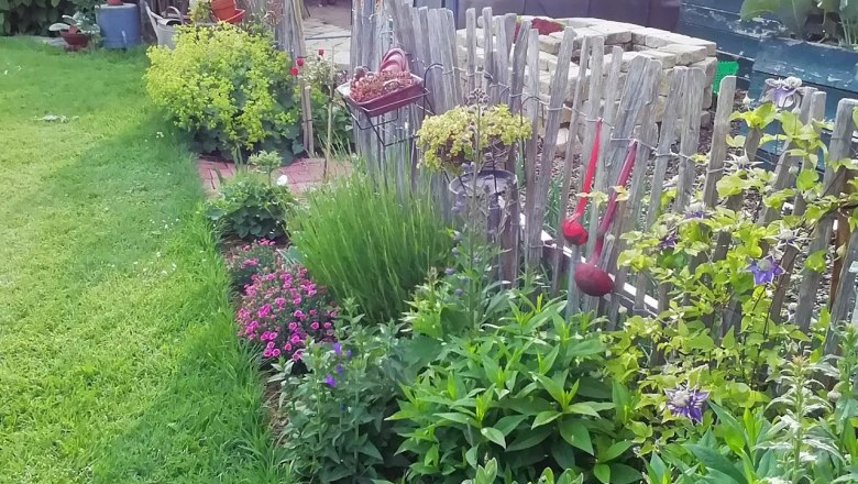 Vegetable garden, © Susanne Bleier A well-tended vegetable garden with greenhouse, wooden fence and flowering plants.