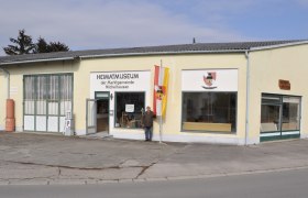 Michelhausen local history museum, © Marktgemeinde Michelhausen Exterior view of the Michelhausen local history museum with yellow building and flag.
