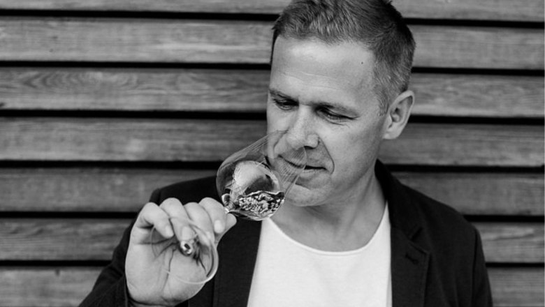 Winemaker, © Silvia Hintermayer A man smells a glass of wine in front of a wooden wall.
