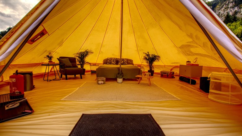 Glamping - Wilderness Center Nasswald, © Jonathan Clark Interior view of a luxury glamping tent with bed, plants and furniture.
