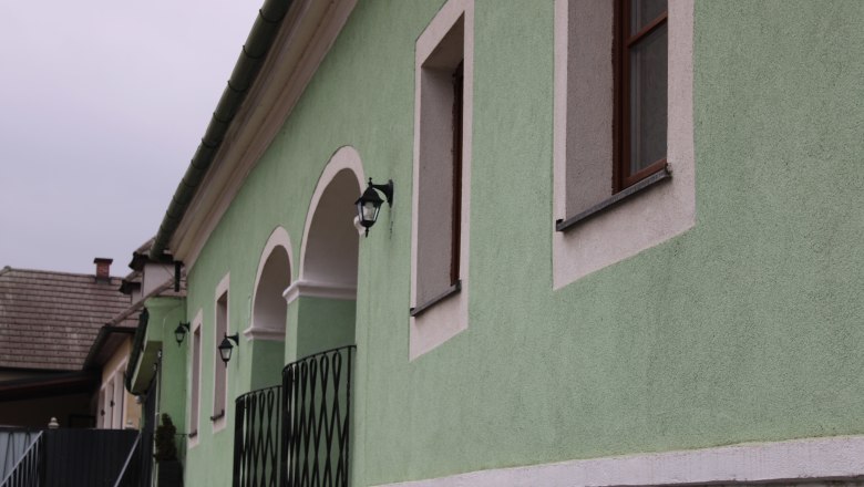 House Danube exterior, © Haus Donau, Hr. Benesics Green building with white window frames and lanterns.