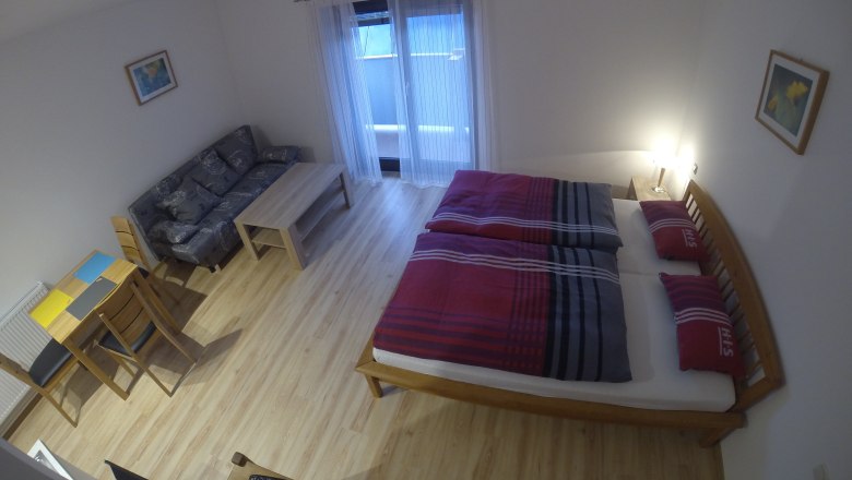 Apartment example, © Zoka A simply furnished apartment with a bed, sofa, table and chairs.