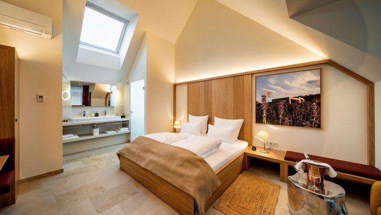Guest house Flora - Gable room, © Herbert Lehmann Modern hotel room with skylight, double bed and stylish furnishings.