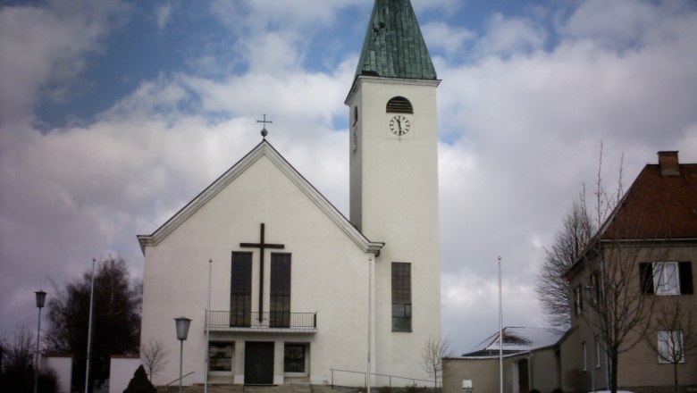 Municipality of Sigmundsherberg, © Gemeinde Sigmundsherberg Church with tower and clock in Sigmundsherberg, surrounded by snow and clouds.