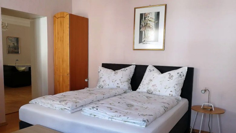 Room example in the Altstadtwohung Mathilde, © Fam. Obernberger Bedroom with double bed, wooden wardrobe and mural.