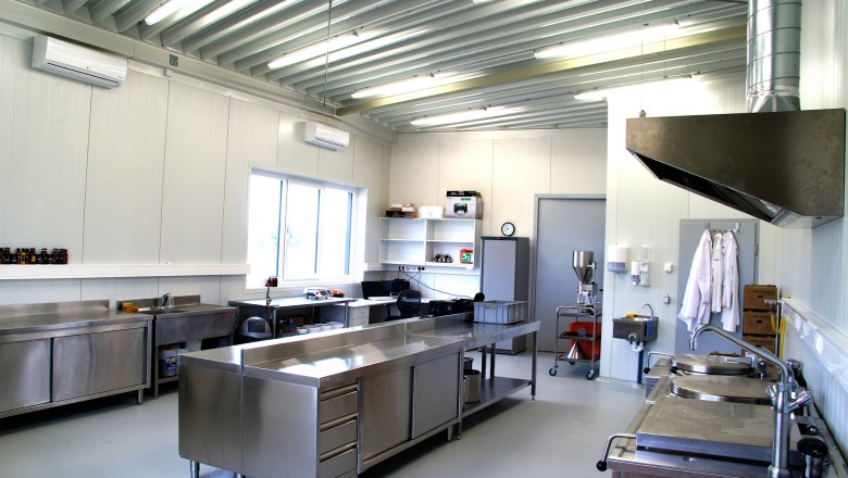 Production Fireland Foods, © zVg Modern industrial kitchen with stainless steel furniture and appliances.