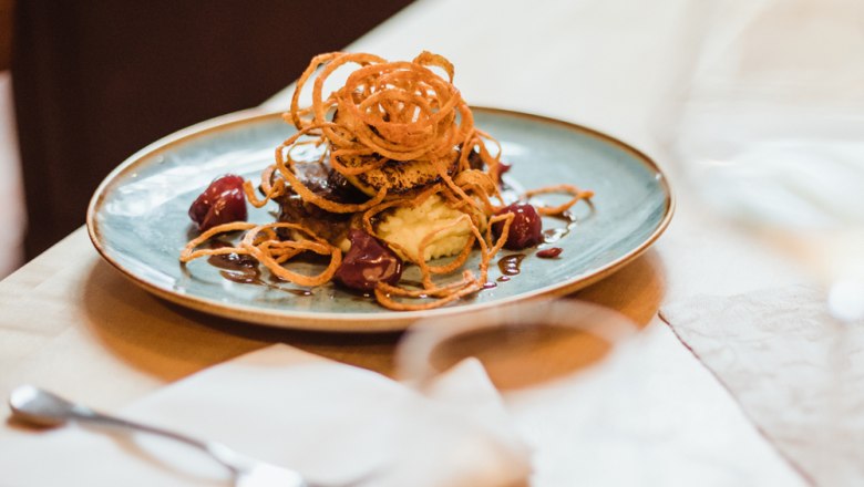 Glazed calf's liver, © Niederösterreich Werbung/David Schreiber Meat dish with onion rings on mashed potatoes and gravy.