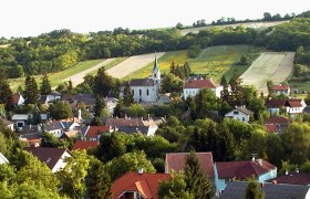 Church of St. Leonhard, © Gemeinde Kreuttal Landscape with church and village in the foreground, surrounded by fields and hills.