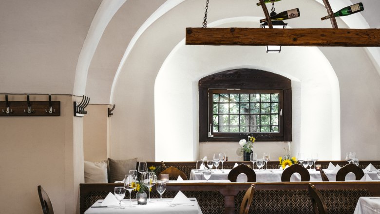 The ambience is exceptional, © Niederösterreich Werbung/Julius Hirtzberger Elegant restaurant with vaulted ceilings, laid tables and wine bottle decorations.
