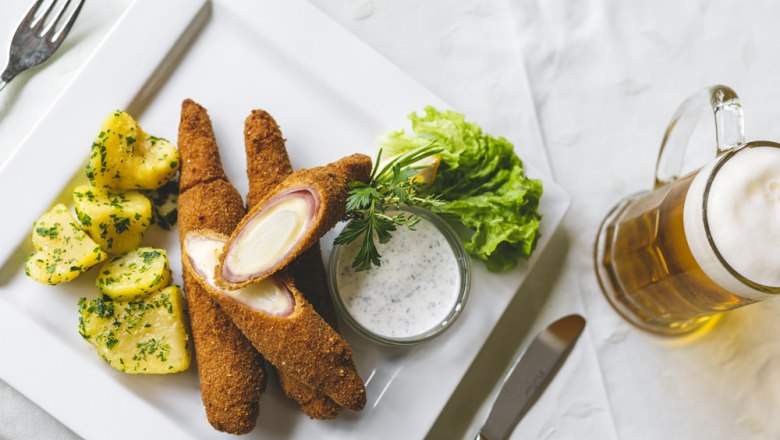 Baked asparagus, © Niederösterreich Werbung/David Schreiber Baked asparagus with potatoes, salad and beer on a white plate.