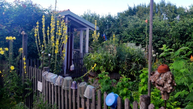 raised_bed_small_color_c_family-mahr, © Familie Mahr A small garden with a raised bed, surrounded by a wooden fence and flowering plants.