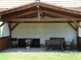Pension Steindl, © Familie Steindl Covered terrace with wooden benches and a flower pot.