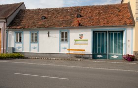 Langau Leisure Museum, © Freizeitmuseum Langau A small, traditional building with red bricks and blue window frames. In front of the building is a yellow bench with the inscription 'Reserved for YOU!