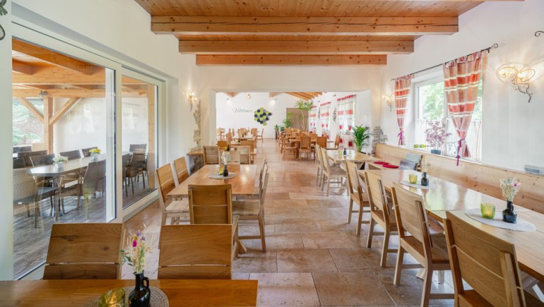 Cozy atmosphere at the Weinviertel wine tavern, © Martin Mathes Interior view of a cozy wine tavern with wooden furniture and decorative curtains.