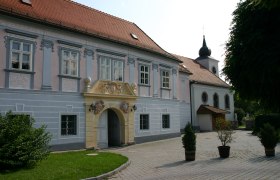 Rectory Pitten, © Thermengemeinden Historic building with ornate entrance and church in the background.