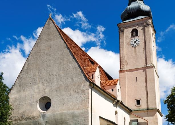 Wiesmath parish church, © Walter Strobl, www.audivision.at Wiesmath parish church with tower, stone cemetery wall and clock against a blue sky.