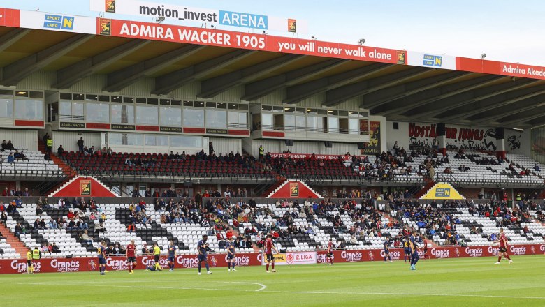 FC Flyeralarm Admira, © FC Flyeralarm Admira Soccer stadium with spectators in the stands and players on the pitch.